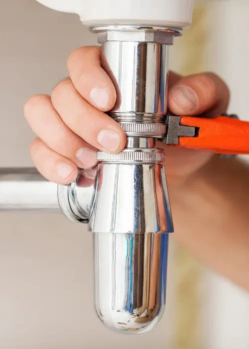 Close up of plumber fixing pipe under sink