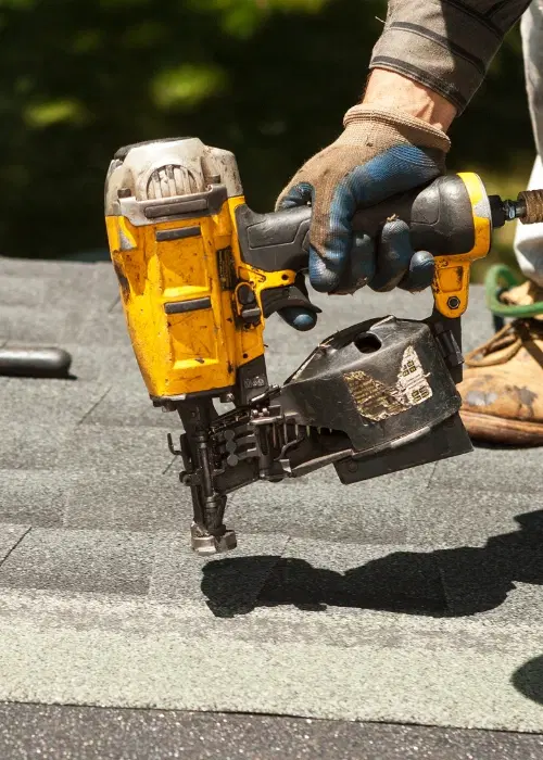 Roofer working on top of roof with power tool