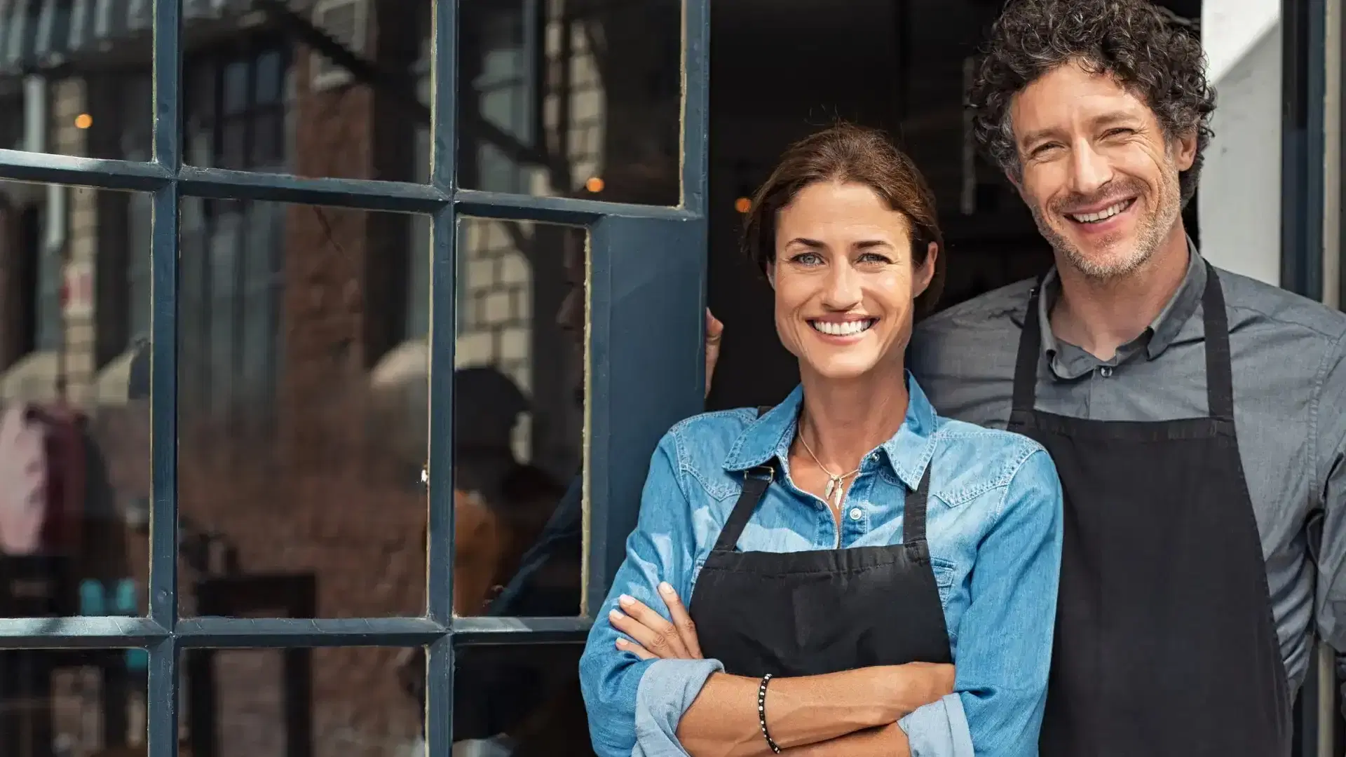 Business owners standing outside storefront